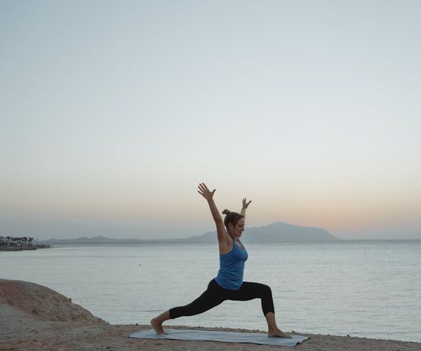 Silhouette of a man stretching against a sunrise, symbolizing energy and well-being.